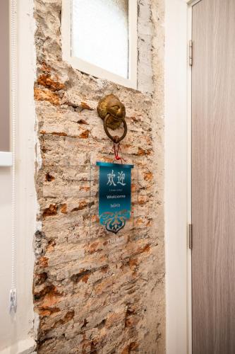 a sign hanging on a brick wall next to a door at Belivin99 Residence Chinatown in Bangkok