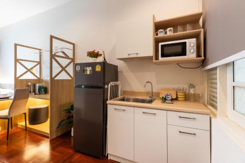 a small kitchen with a refrigerator and a sink at Belivin99 Residence Chinatown in Bangkok