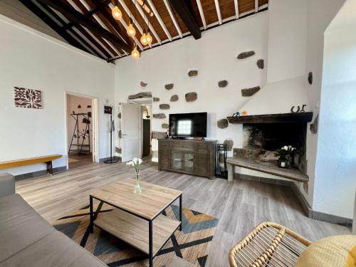 a living room with a table and a fireplace at AZ Solar Cottage and Secret Garden in São Vicente Ferreira