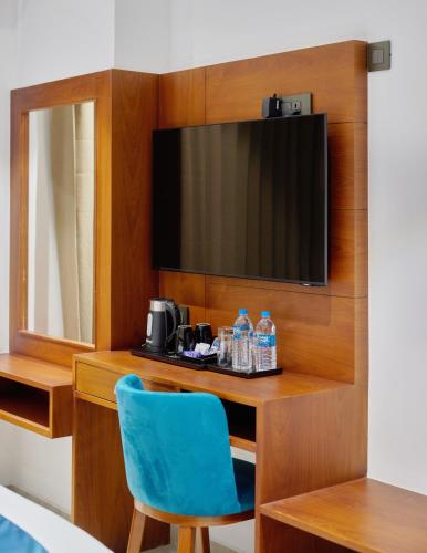 a room with a desk with a television and a blue chair at Q-White Crescent in Cochin
