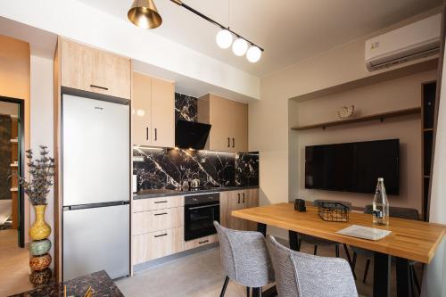 a kitchen with a wooden table and a refrigerator at Sapphire Horizon Suites in Kissamos