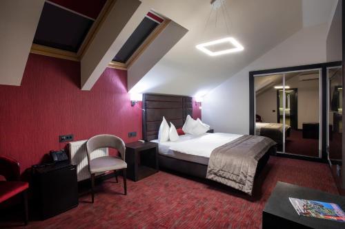 a hotel room with a bed and a chair at The Fifth Floor by Old Town Hotel in Timişoara
