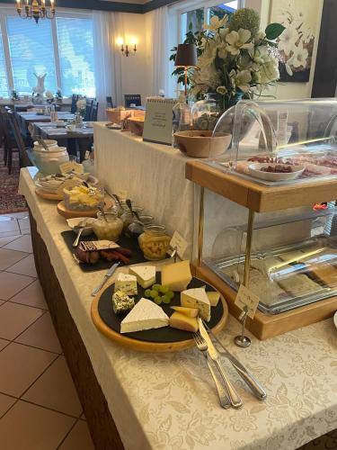 a buffet with cheese and other food on a table at Flairhotel am Wörthersee in Velden am Wörthersee