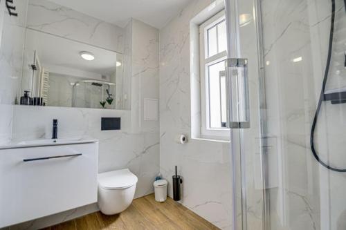 a white bathroom with a toilet and a shower at 1B Neu renoviert 3 Zi Whg 5 Betten 43,29qm in Schwedt