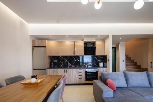 a kitchen and living room with a couch and a table at Sapphire Horizon Suites in Kissamos