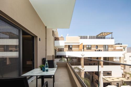 a balcony with a table and a building at Sapphire Horizon Suites in Kissamos