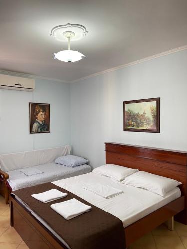 a bedroom with two beds with towels on top at Eden Apartment in Pogradec