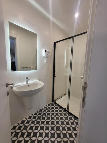a bathroom with a sink and a mirror at Carlton Hotel in Sliema