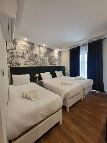 two beds in a room with blue curtains at Carlton Hotel in Sliema