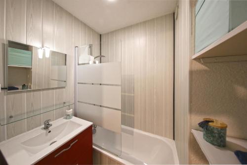 a bathroom with a sink and a mirror and a shower at La Brise de Donville - A 300m de la plage in Donville-les-Bains