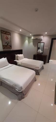 Ένα ή περισσότερα κρεβάτια σε δωμάτιο στο Taleen Serviced Apartments Al Aqiq