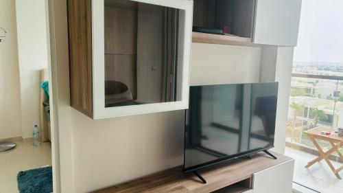 a cabinet with a television in a living room at Damac Golf vita in Dubai