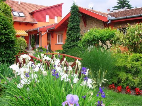 a garden with flowers in front of a house at Green Park Villa in Eger