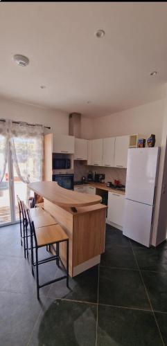 una cucina con un tavolo e un frigorifero bianco di Maison Vacance Proche De Calvi a Calenzana