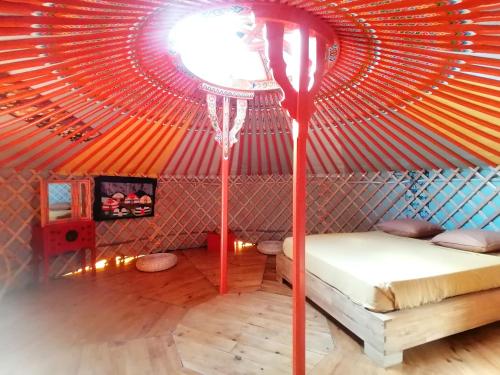- une chambre avec un lit dans une yourte dans l'établissement Yourte Mongole Aux nuits insolites d'Argoumbat, à Beaumont-de-Lomagne