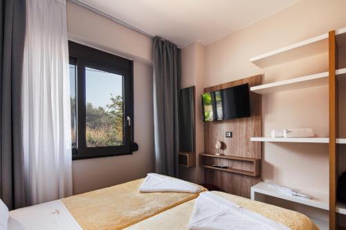 a hotel room with two beds and a window at Sapphire Horizon Suites in Kissamos