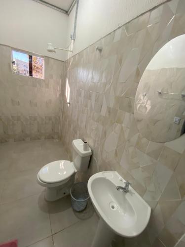a bathroom with a sink and a toilet and a mirror at Hotel Pousada Do Sol II in Aragarças