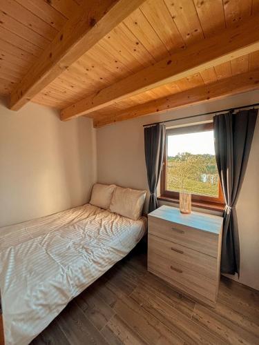 a small bedroom with a bed and a window at Domek u Ani in Giżycko