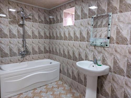 a bathroom with a sink and a tub and a toilet at Mammadaghali rental house in Mǝmmǝdağalı