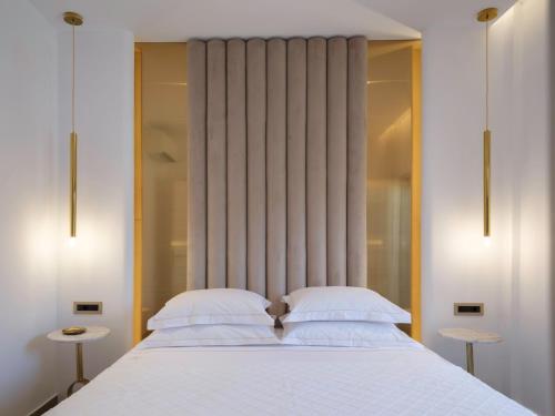 a bedroom with a white bed with a large window at Golden Luxury Suites in Balíon