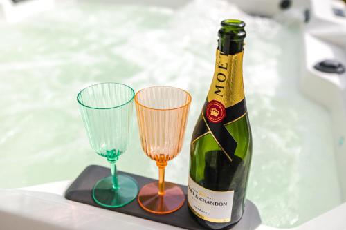 a bottle of champagne and two wine glasses at IoanaGuestHouse in Turda