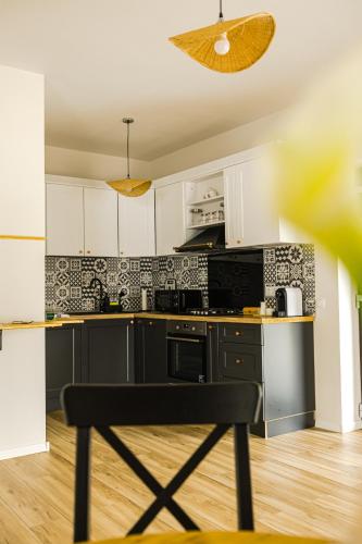 a kitchen with white cabinets and black appliances at IoanaGuestHouse in Turda