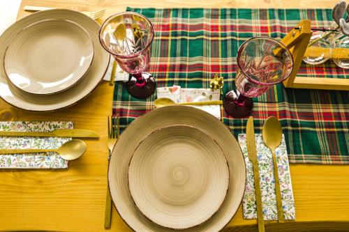 a wooden table with plates and wine glasses on it at IoanaGuestHouse in Turda
