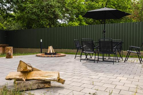a patio with tables and chairs and an umbrella at IoanaGuestHouse in Turda