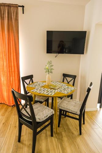 a dining room table with two chairs and a yellow table at IoanaGuestHouse in Turda