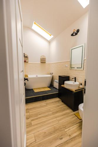 a bathroom with a tub and a sink and a toilet at IoanaGuestHouse in Turda