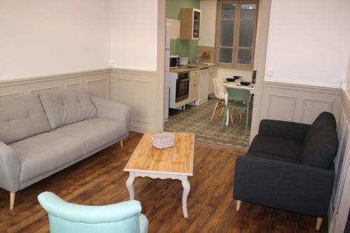 un salon avec un canapé et une table dans l'établissement Le quai 2009, à Rethel