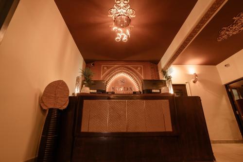 a restaurant with a bar with a chandelier at Sinon Baga Retreat in Baga