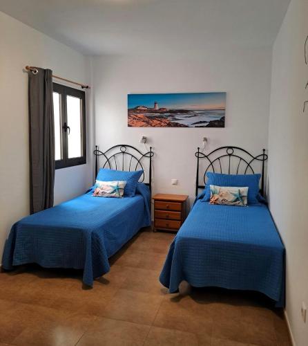 a bedroom with two beds and a window at Vv Salitre in La Santa