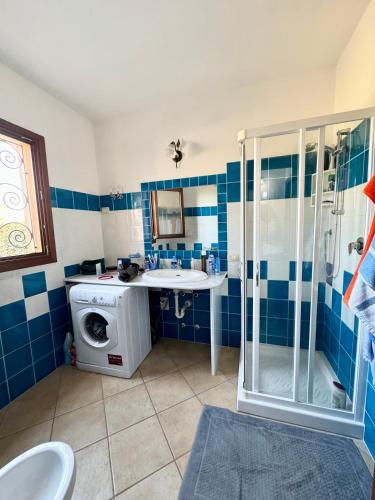 a bathroom with a shower and a washing machine at Case vacanza Corallo - San Teodoro centro in San Teodoro