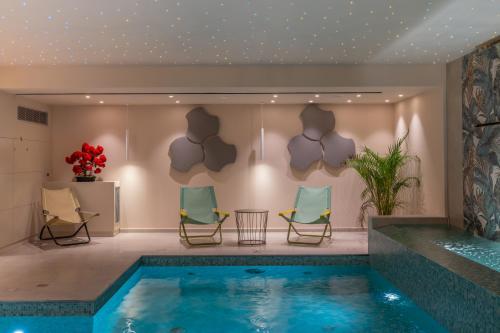 a pool in a room with chairs and a table at Ionian Plaza Hotel & Spa in Argostoli