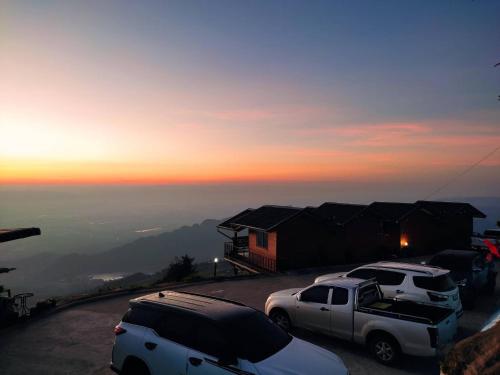 two cars parked in a parking lot at sunset at เมฆสวรรค์ ภูทับเบิก in Ban Maeo Thap Boek