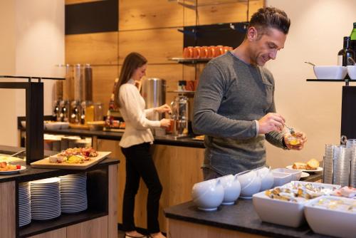 a man and a woman in a kitchen preparing food at Hotel Zum Mohren in Reutte