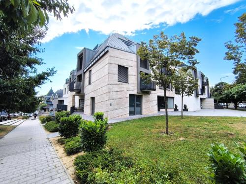 a building on a street with a grass yard at Sunshine Residence Boutique Apartment in Hévíz