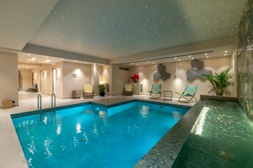 a swimming pool in a hotel with blue water at Ionian Plaza Hotel & Spa in Argostoli