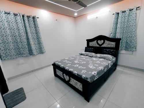 a bedroom with a bed in a room with curtains at Serene Sanctuary in Hyderabad
