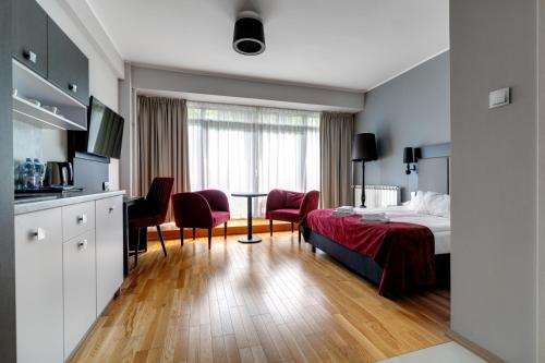 a hotel room with a bed and a table and chairs at Silesia Krynica in Krynica Zdrój