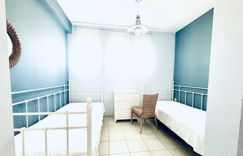 a bedroom with two beds and a chair at Ktima Holoway Apartments in Therma
