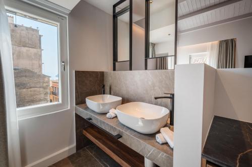 a bathroom with two sinks and a mirror at Kantoni Suites in Corfu Town
