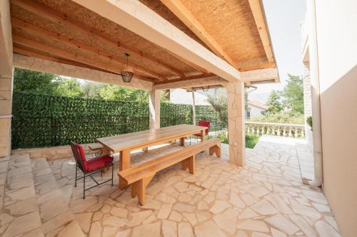 a wooden table and chairs on a patio at Bradasevic Apart Resort Tivat lux in Tivat