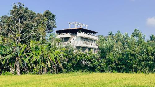 a building on the side of a hill next to a field at Ceylon's House in Hikkaduwa