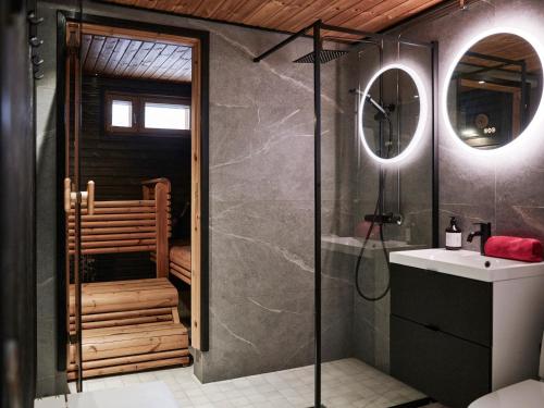 ロヴァニエミにあるVilla Kyyhkynenのシャワー、洗面台、鏡を備えたバスルーム