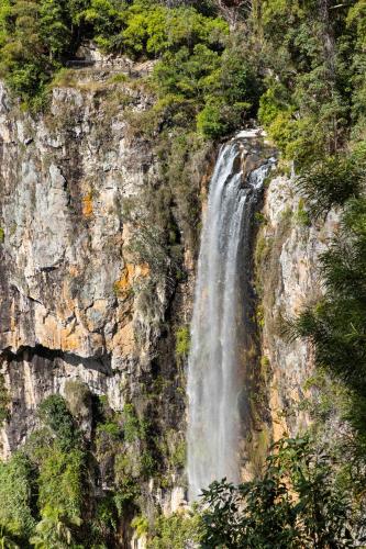 a waterfall on the side of a rocky cliff at Secluded Luxury 2BR Rainforest Retreat Free Wi-Fi in Springbrook