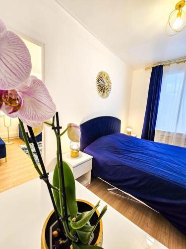 - une chambre avec un lit bleu et une plante sur une table dans l'établissement Appartement 2 étoiles cosy et chic à Vaires sur Marne Entre disney et Paris, à Vaires-sur-Marne