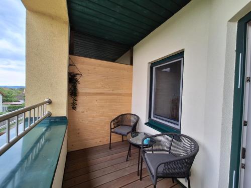 a balcony with two chairs and a swimming pool at Ferienwohnung Traismauer in Wagram ob der Traisen