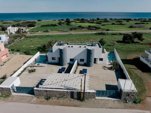 an aerial view of a house with the ocean in the background at Villa Vasaltis & Selestitis in Gennadi